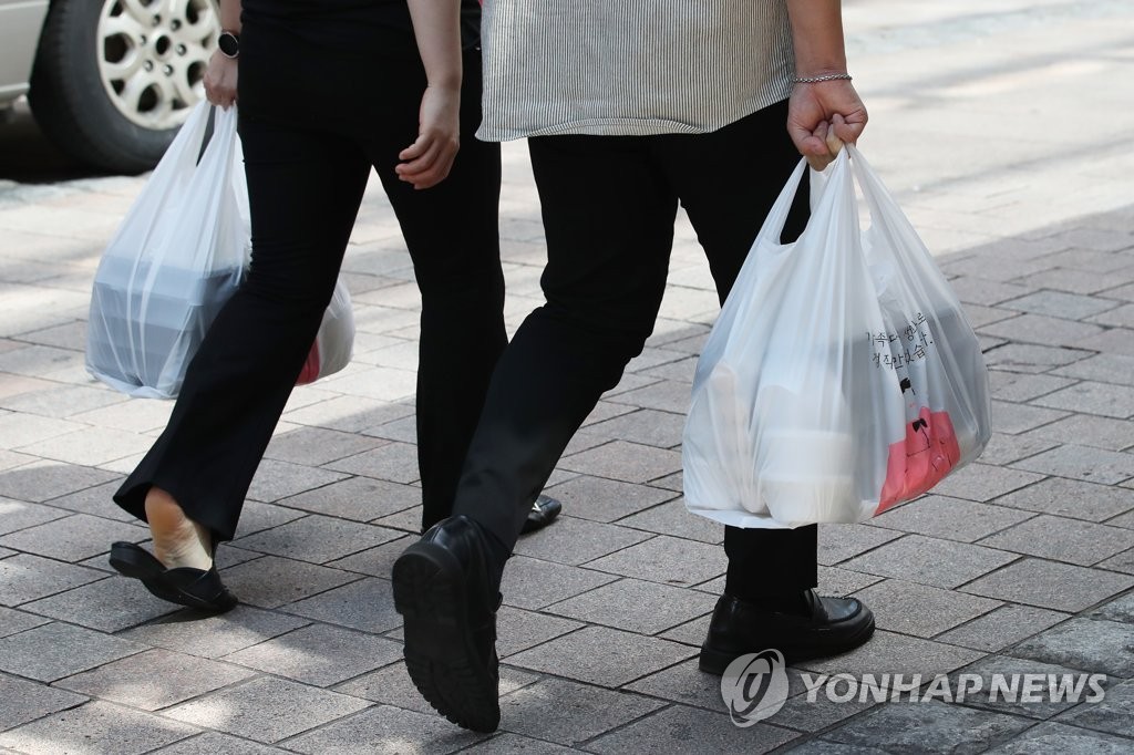 Workers carry takeout lunch boxes in central Seoul on Sept. 4, 2020. (Yonhap)