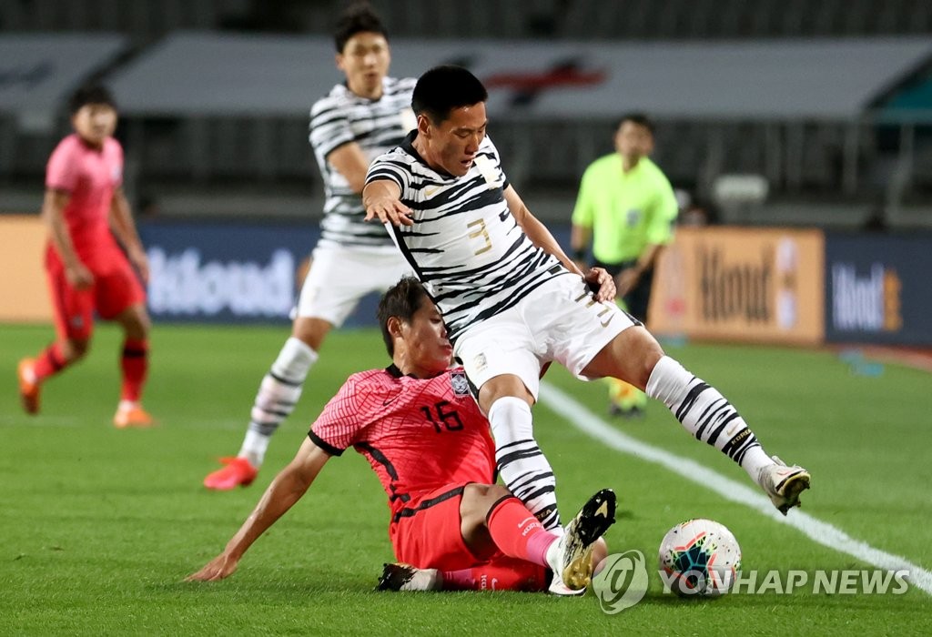 Han Chan-hee of the of the South Korean men's under-23 national football team (L) tackles Sim Sang-min of the senior national team during their exhibition match at Goyang Stadium in Goyang, Gyeonggi Province, on Oct. 12, 2020. (Yonhap)