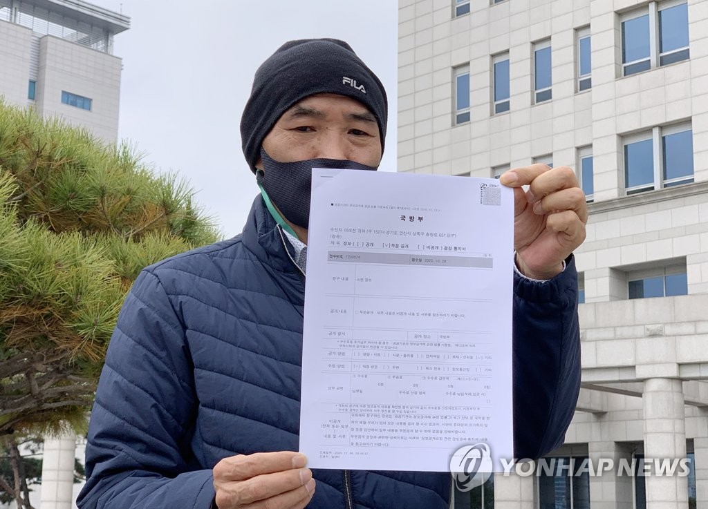 Lee Rae-jin, the elder brother of a South Korean official killed by North Korean soldiers while drifting in its waters in September, holds a document showing the government's decision to partially disclose information on the incident after a meeting with Defense Minister Suh Wook in Seoul on Nov. 6, 2020. (Yonhap) 