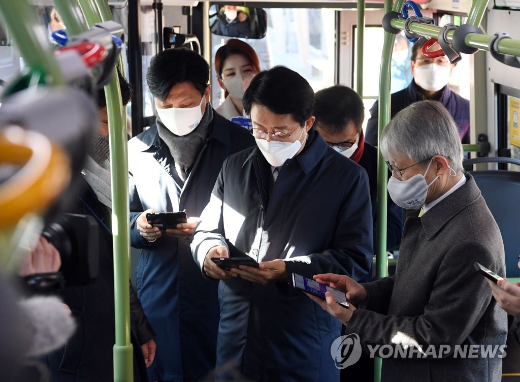 ICT Minister Choi Ki-young (R) and two ruling party lawmakers access free Wi-Fi services on a bus in Seoul on Dec. 14, 2020, as South Korea has established the network on all city buses in operation in the country. (Yonhap)