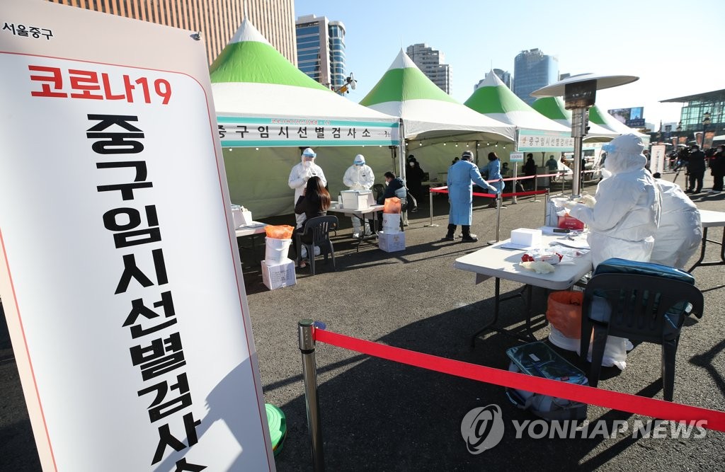 Health workers conduct coronavirus tests on citizens at a temporary testing center set up in front of Seoul Station in central Seoul on Dec. 20, 2020. (Yonhap) 