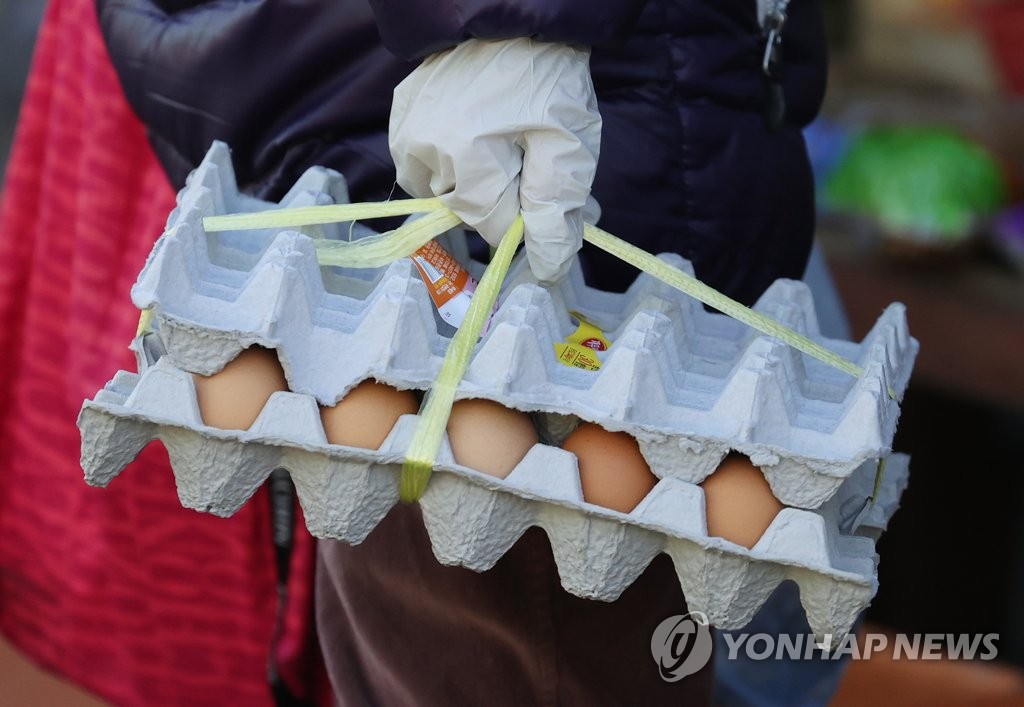 A shopper carries a carton of eggs at a marketplace in eastern Seoul on Jan. 27, 2021. (Yonhap)