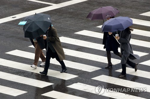 우산을 쓴 채 횡단보도를 건너는 시민들. [연합뉴스 자료사진]