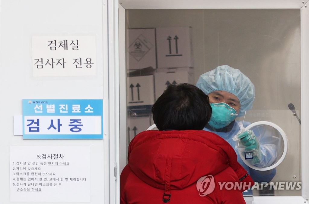 A medical worker carries out COVID-19 tests at a makeshift clinic in Seoul on Feb. 21, 2021. (Yonhap)