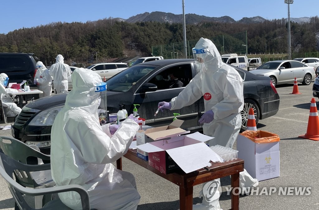 Officials carry out COVID-19 tests at a drive-thru makeshift clinic in Pyeongchang, 182 kilometers east of Seoul, on March 10, 2021. (Yonhap) 
