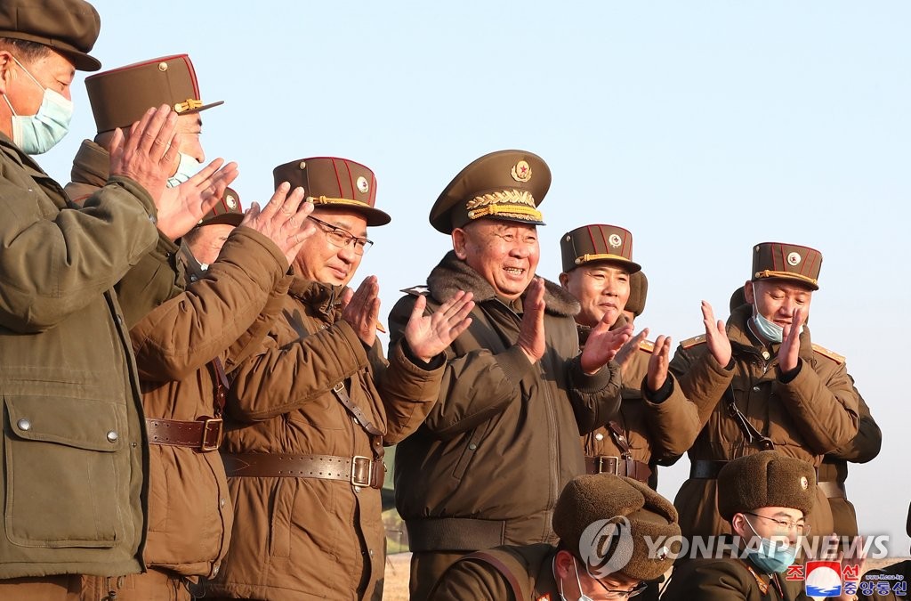 Ri Pyong-chol (4th from L), vice chairman of the Central Military Commission of North Korea's ruling Workers' Party, applauds as North Korea test-fires a new type of a tactical guided missile that was launched into the East Sea from the North Korean town of Hamju, South Hamgyong Province, on March 25, 2021, in this photo released by the North's official Korean Central News Agency. The North's leader Kim Jong-un did not oversee the launch. South Korea's military said the previous day that the North fired what appeared to be two short-range ballistic missiles into the East Sea. (For Use Only in the Republic of Korea. No Redistribution) (Yonhap)