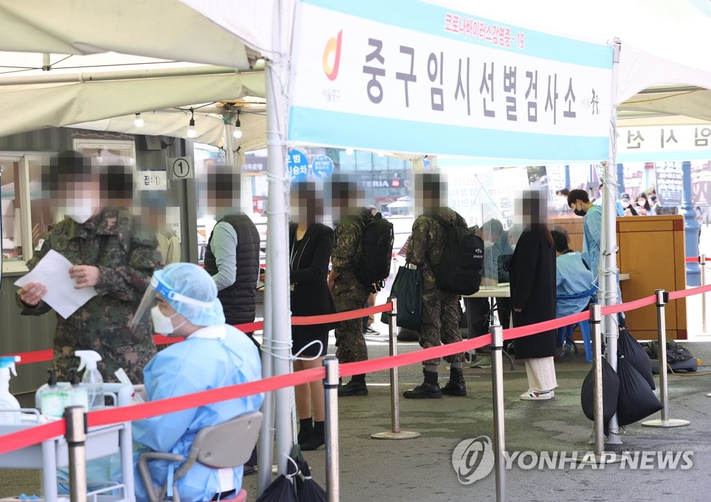 This photo, taken on April 1, 2021, shows citizens waiting in line to receive COVID-19 tests at a makeshift testing site in front of Seoul Station in central Seoul. (Yonhap)