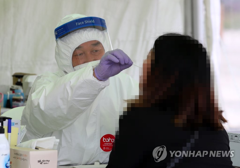 A woman receives a COVID-19 test at a makeshift clinic in Gwangju, 330 kilometers south of Seoul, on April 6, 2021. (Yonhap) 