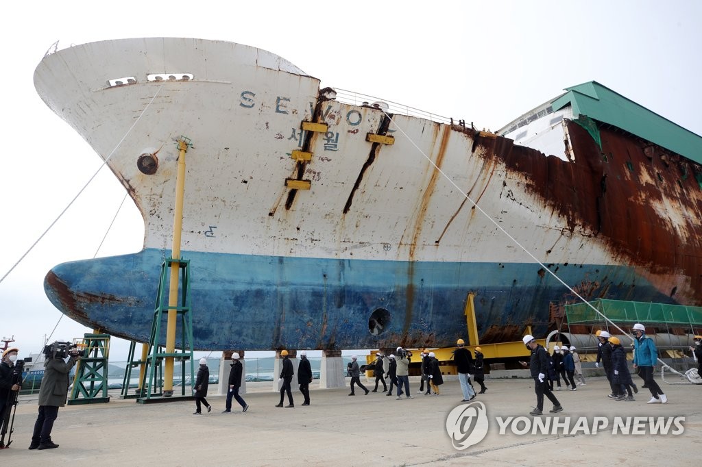 Family members of the victims of the Sewol ferry sinking look around the wreckage of the boat at a port in Mokpo, 410 kilometers south of Seoul, on April 16, 2021, the seventh anniversary of the tragic accident that claimed more than 300 lives, mostly teenagers on a school excursion. (Yonhap)