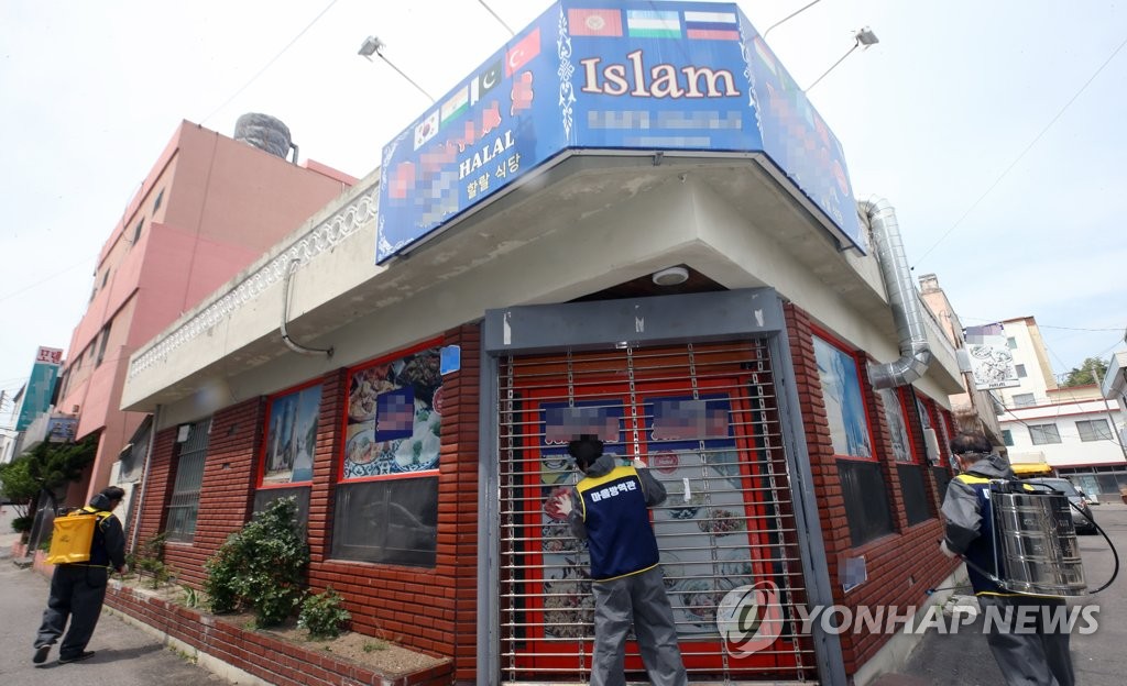 This May 6, 2021, file photo shows disinfection workers sterilizing a restaurant in Gangneung, about 240 kilometers east of Seoul, to contain the spread of COVID-19 in the city. (Yonhap)