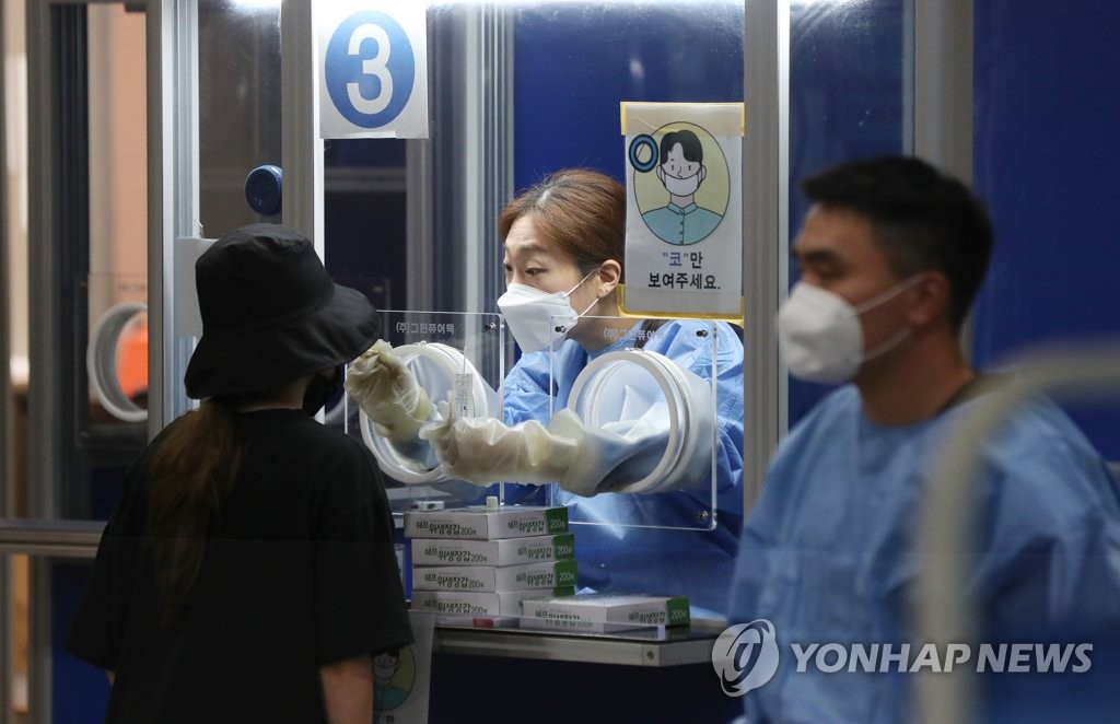 A person gets a COVID-19 test at a screening station in southern Seoul on July 21, 2021. (Yonhap)