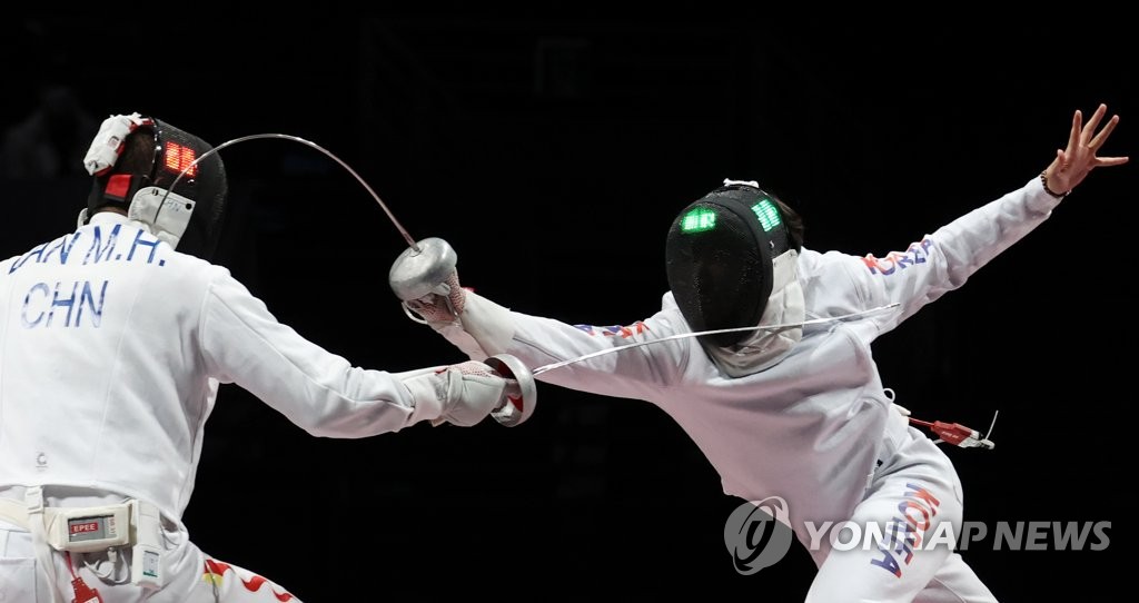 Park Sang-young of South Korea (R) scores a point against Lan Minghao of China during the bronze medal match of the men's epee team fencing event at the Tokyo Olympics at Makuhari Messe Hall B in Chiba, Japan, on July 30, 2021. (Yonhap)