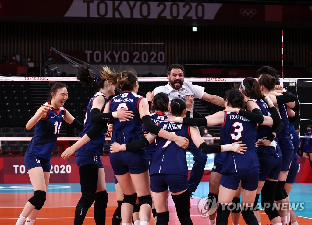 South Korean players and head coach Stefano Lavarini (C) celebrate their victory in the Pool A match against Japan in women's volleyball at the Tokyo Olympics at Ariake Arena in Tokyo on July 31, 2021. (Yonhap)