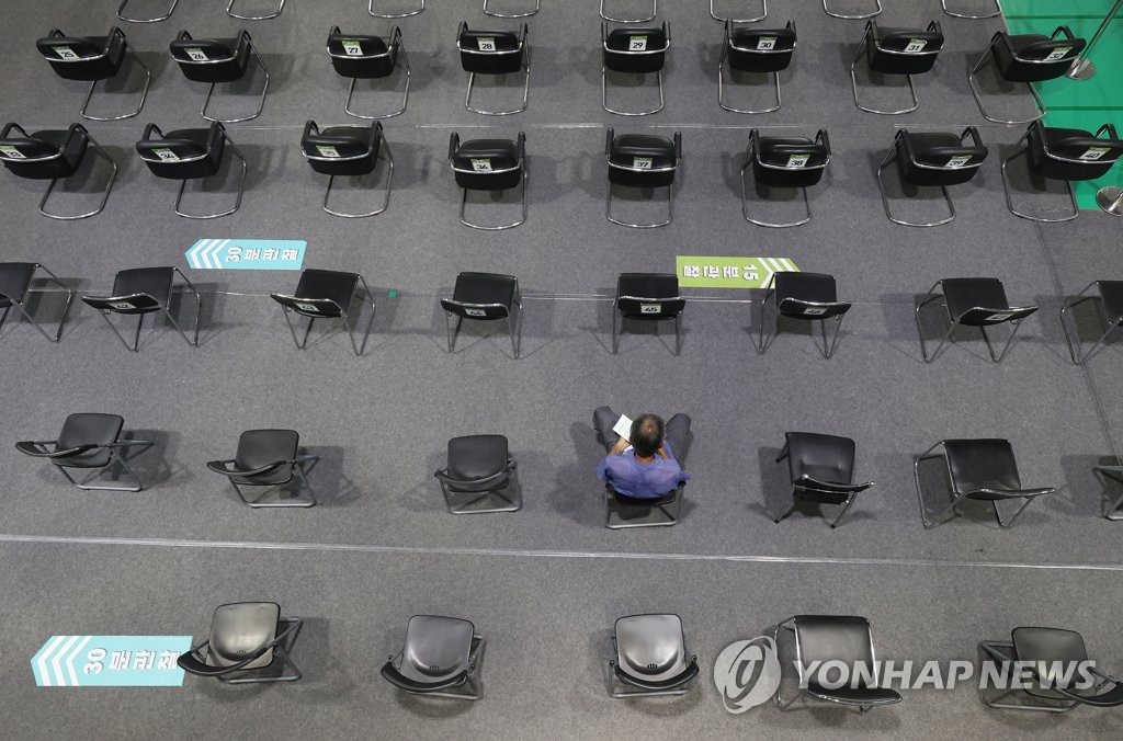 A citizen sits in a waiting room to be monitored for potential side effects after receiving a COVID-19 jab at a gym in western Seoul on Aug. 3, 2021. (Yonhap)