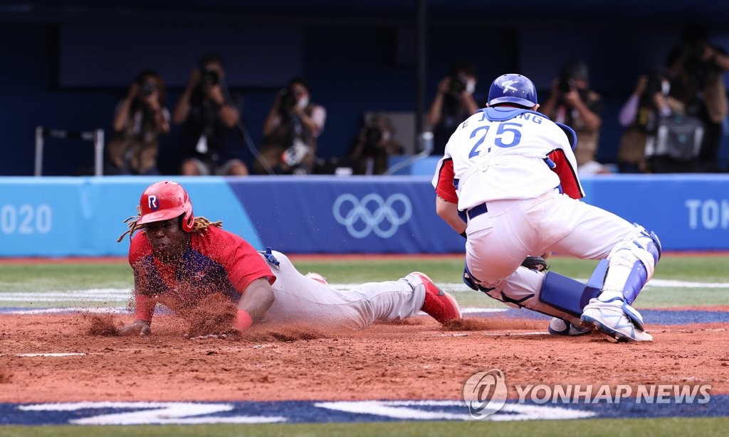 Johan Mieses of the Dominican Republic (L) scores past South Korean catcher Yang Eui-ji during the top of the fifth inning of the bronze medal game at the Tokyo Olympic baseball tournament at Yokohama Stadium in Yokohama, Japan, on Aug. 7, 2021. (Yonhap)