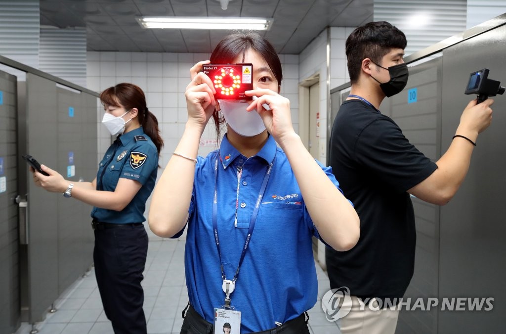 This file photo shows police officers using devices to check for hidden cameras in a public bathroom at a subway station in Incheon, about 40 kilometers west of Seoul, on Aug. 10, 2021, as part of a campaign to root out sex crimes. (Yonhap)