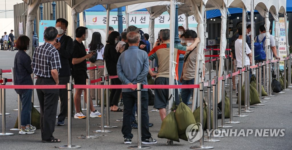 People wait in a line at a makeshift clinic in central Seoul on Sept. 3, 2021. (Yonhap)