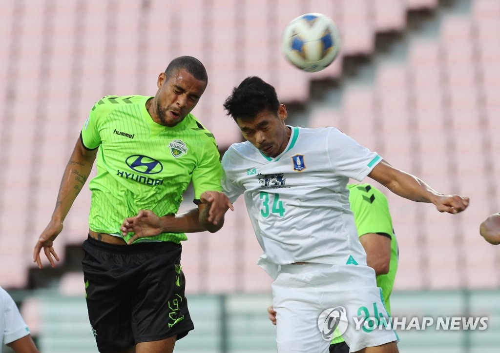 In this file photo from Sept. 15, 2021, Gustavo of Jeonbuk Hyundai Motors (L) attempts a header past Sarawut Koedsri of BG Pathum United during the clubs' round of 16 match at the Asian Football Confederation Champions League at Jeonju World Cup Stadium in Jeonju, 240 kilometers south of Seoul. (Yonhap)