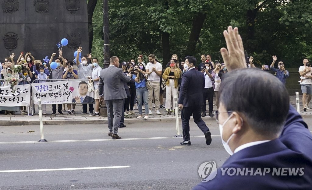 South Korean President Moon Jae-in (R) waves to ethnic Koreans greeting him in New York on Sept. 20, 2021 in this photo provided by Cheong Wa Dae. (PHOTO NOT FOR SALE) (Yonhap)