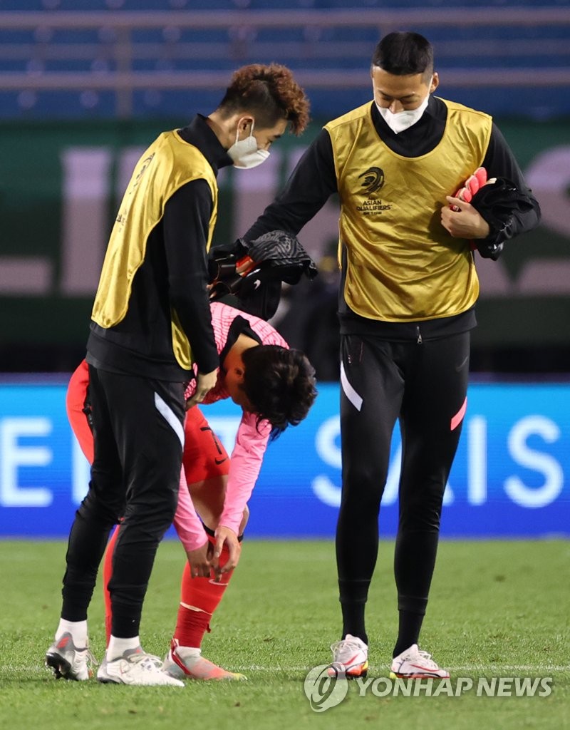Son Heung-min of South Korea (C) is helped up by teammates Jo Hyeon-woo (L) and Gu Sung-yun after the team's 2-1 victory over Syria in a Group A match in the final Asian qualifying round for the 2022 FIFA World Cup at Ansan Wa Stadium in Ansan, Gyeonggi Province, on Oct. 7, 2021. (Yonhap)