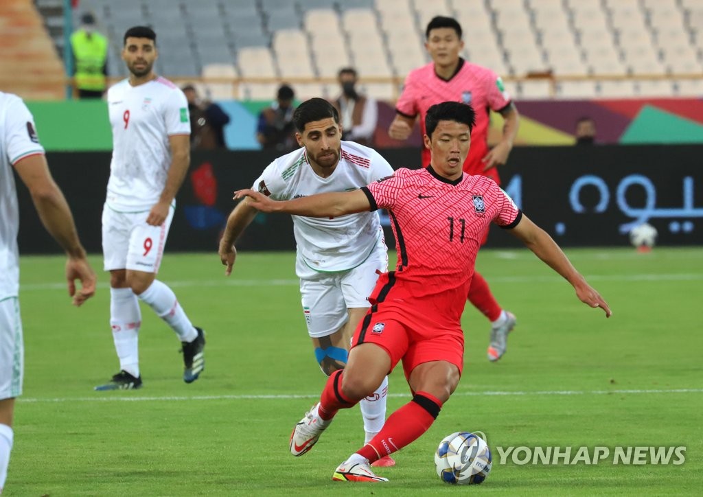 Hwang Hee-chan of South Korea (R) controls the ball against Iran during the teams' Group A match in the final Asian qualifying round for the 2022 FIFA World Cup at Azadi Stadium in Tehran on Oct. 12, 2021. (Yonhap)