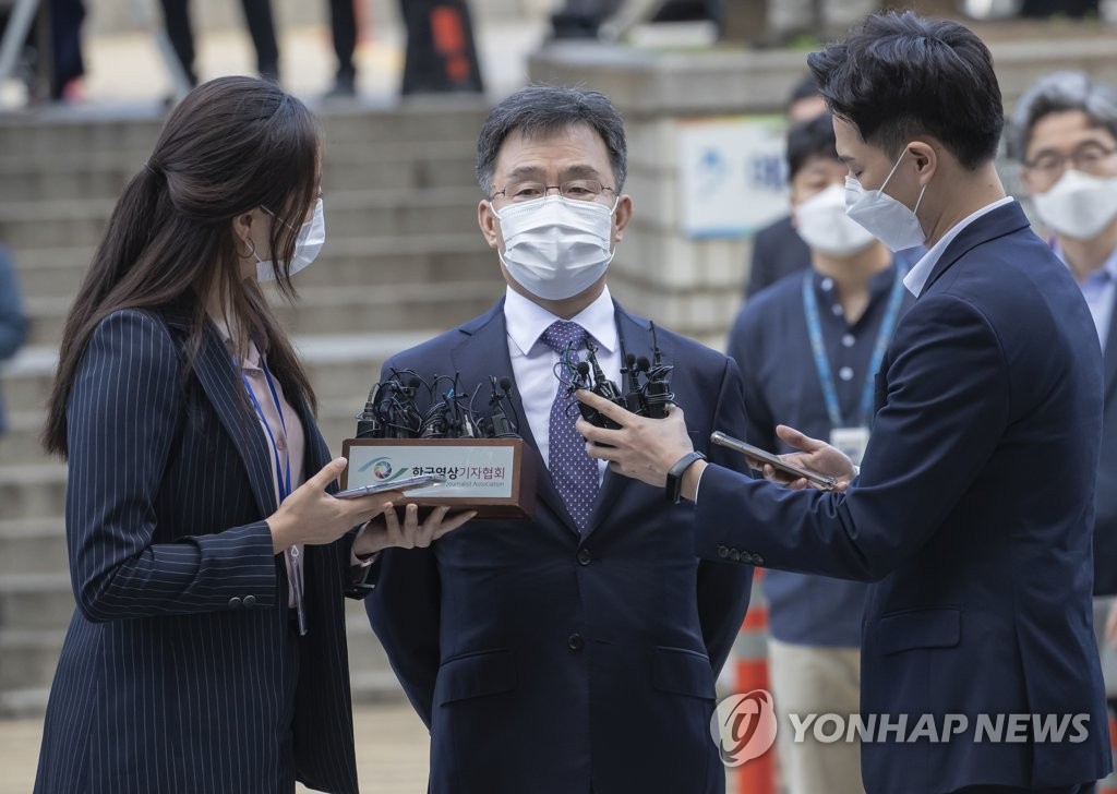 Kim Man-bae (C), owner of Hwacheon Daeyu, an asset management firm, speaks to reporters after arriving at the Seoul Central District Court on Oct. 14, 2021, for a hearing. (Yonhap)