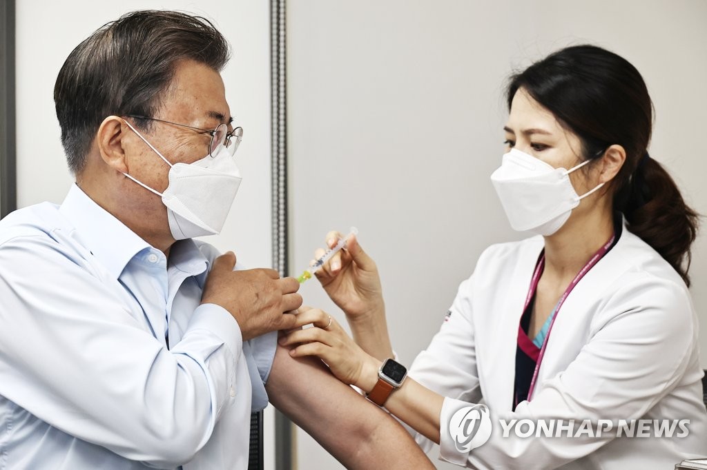 La foto, tomada el 15 de octubre de 2021, muestra al presidente, Moon Jae-in (izda.), recibiendo la vacuna de refuerzo contra el COVID-19.
