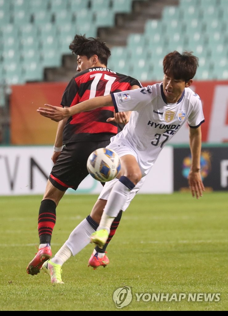 Lim Sang-hyub of Pohang Steelers (L) and Yun Il-lok of Ulsan Hyundai FC battle for the ball during their clubs' semifinal match at the Asian Football Confederation Champions League at Jeonju World Cup Stadium in Jeonju, 240 kilometers south of Seoul, on Oct. 20, 2021. (Yonhap)