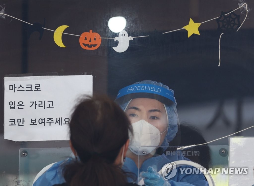 Une décoration de Halloween a été installée au centre de dépistage du Covid-19 de la gare de Séoul, le mardi 26 octobre 2021. Les autorités sanitaires ont rapporté mardi 1.266 nouvelles infections.