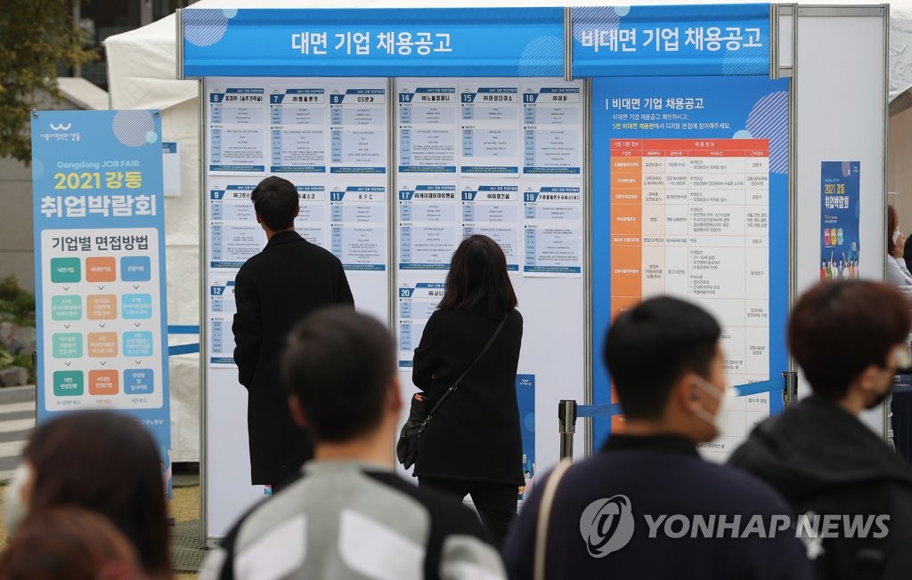 La foto de archivo, tomada el 4 de noviembre de 2021, muestra a demandantes de empleo mirando un tablón de anuncios en una feria de empleo, en el este de Seúl.