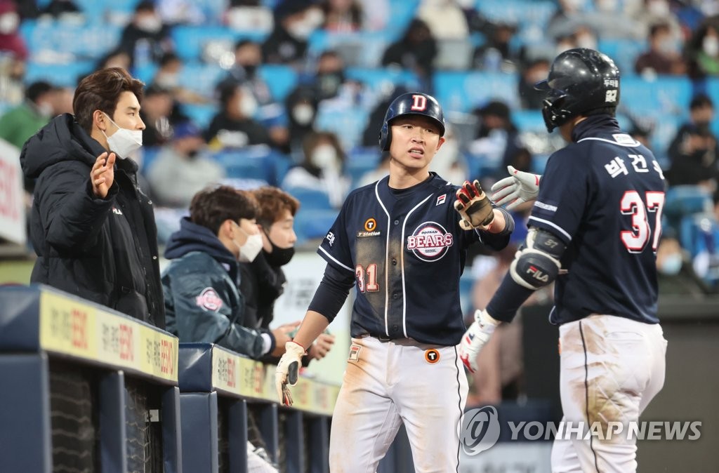 Jung Soo-bin of the Doosan Bears (C) is congratulated by teammate Park Kun-woo (R) after scoring a run against the Samsung Lions in the top of the eighth inning during Game 1 of the second round in the Korea Baseball Organization postseason at Daegu Samsung Lions Park in Daegu, some 300 kilometers southeast of Seoul, on Nov. 9, 2021. (Yonhap)