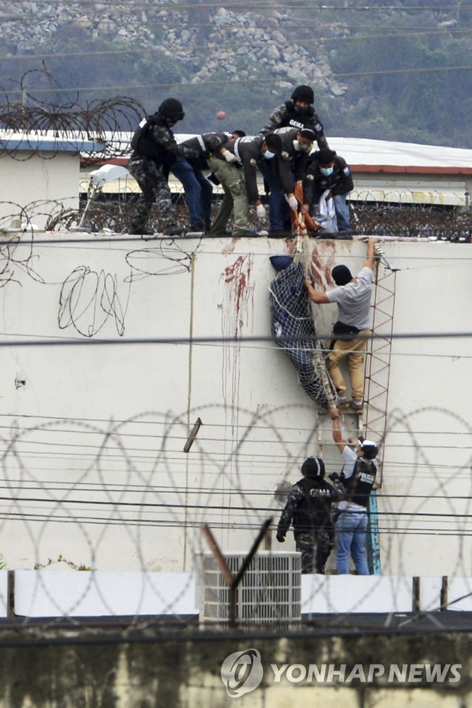 교도소 지붕서 재소자 시신 수습하는 에콰도르 경찰