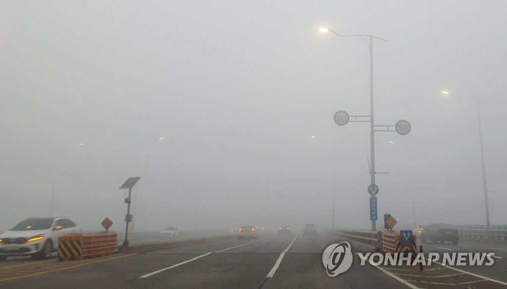 A road in Incheon, west of Seoul, is shrouded in fine dust on Nov. 20, 2021. (Yonhap)