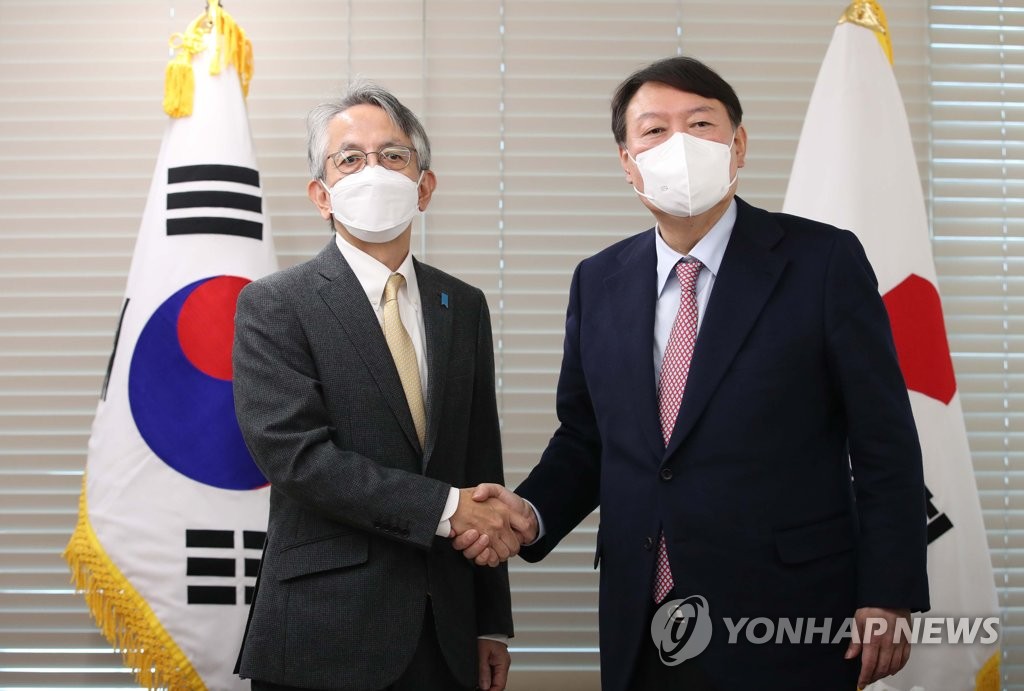 Yoon Seok-youl (R), the presidential candidate of the main opposition People Power Party, poses for a photo with Japanese Ambassador to South Korea Koichi Aiboshi during their meeting at the party's headquarters in Seoul on Nov. 26, 2021. (Pool photo) (Yonhap)