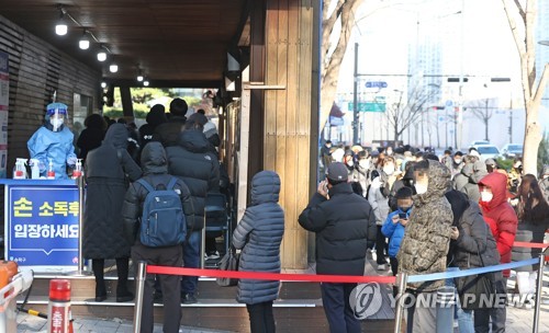 Los ciudadanos esperan en fila, el 28 de noviembre de 2021, para someterse a las pruebas del COVID-19 en un centro médico estatal en el sur de Seúl.