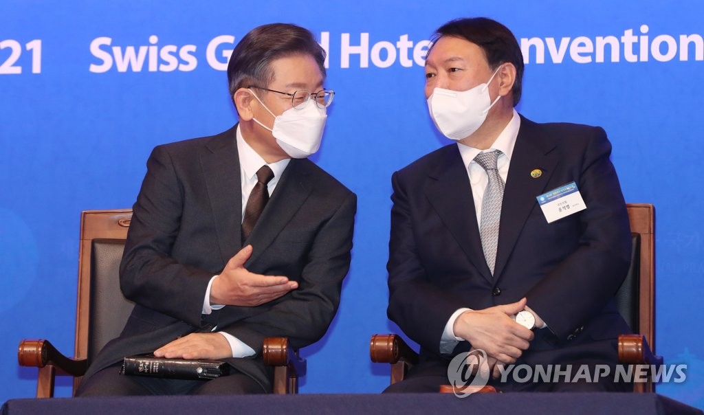 Lee Jae-myung (à g.), le candidat officiel à l'élection présidentielle du Parti démocrate (PD), discute avec Yoon Suk-yeol, celui du Parti du pouvoir du peuple (PPP), lors de la 53e oraison nationale à l'hôtel Swiss Grand à Séoul, le jeudi 2 décembre 2021. (Pool photo)