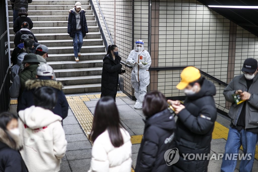 Des personnes font la queue pour se faire dépister pour le nouveau coronavirus (Covid-19) depuis un passage souterrain devant le centre médical public de Songpa, dans le sud-est de Séoul, le jeudi 9 décembre 2021. 