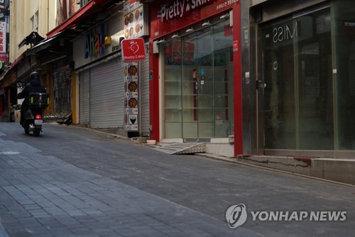 La foto, tomada el 11 de enero de 2022, muestra un callejón con tiendas cerradas en Myeongdong, un popular barrio comercial de Seúl, en medio de la pandemia.