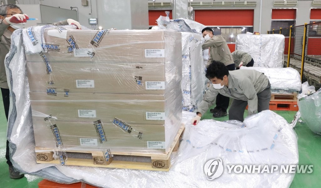Workers at a distribution center in the central county of Ochang open boxes containing Paxlovid, COVID-19 treatment pills developed by U.S. pharmaceutical giant Pfizer Inc., on Jan. 13, 2022. The first batch of Paxlovid for 21,000 people arrived in South Korea earlier in the day. (Yonhap)
