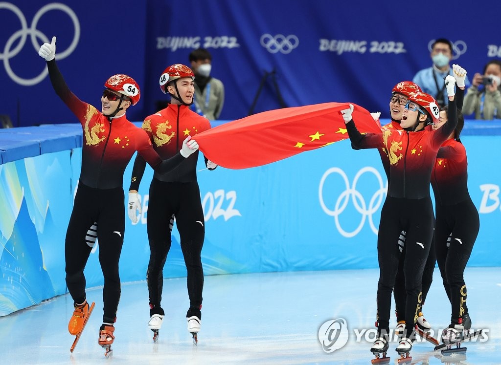 Members of the Chinese short track speed skating mixed relay team celebrate their gold medal at the Beijing Winter Olympics at Capital Indoor Stadium in Beijing on Feb. 5, 2022. (Yonhap)