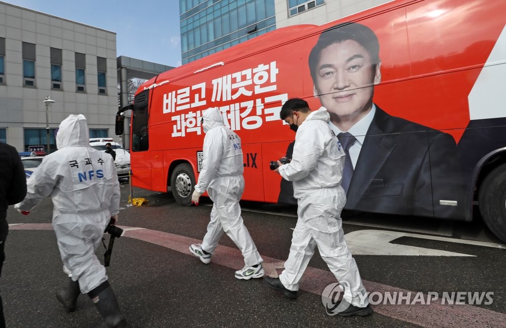 Police investigators examine a bus at a police station in Cheonan, about 90 kilometers south of Seoul, on Feb. 16, 2022, one day after two campaign workers for minor opposition presidential candidate Ahn Cheol-soo were found dead in the campaign bus apparently due to gas poisoning. (Yonhap)