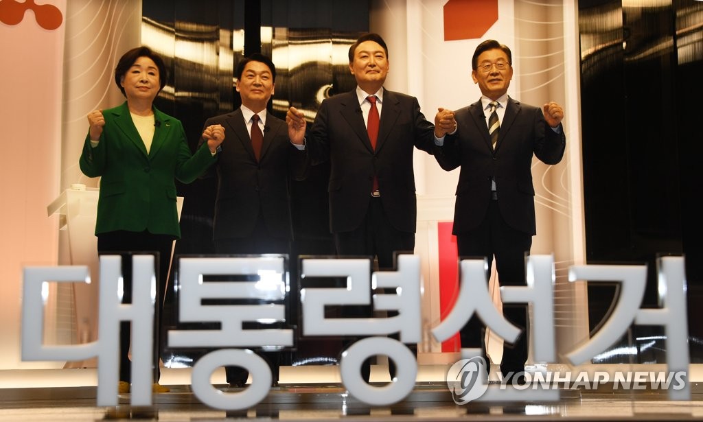 Presidential candidates (from L to R) Sim Sang-jeung of the Justice Party, Ahn Cheol-soo of the People's Party, Yoon Suk-yeol of the People Power Party and Lee Jae-myung of the Democratic Party pose for a group photo ahead of their TV debate at an SBS TV studio in Seoul on Feb. 25, 2022. (Pool photo) (Yonhap)