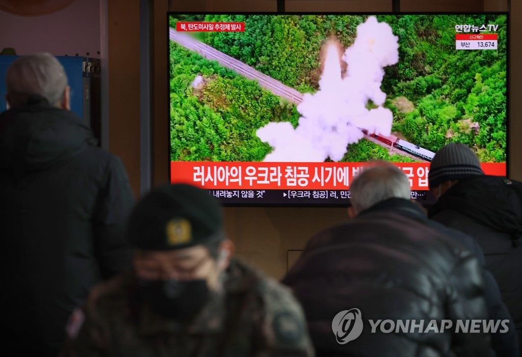 Des personnes regardent la nouvelle concernant le tir de missile balistique présumé de la Corée du Nord, à la gare de Séoul le dimanche 27 février 2022. 