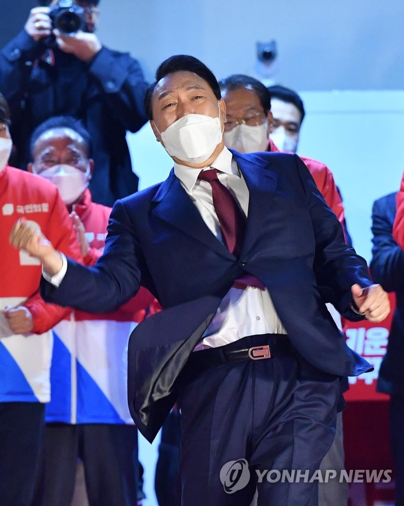 Yoon Suk-yeol of the main opposition People Power Party makes his signature uppercut gesture as he acknowledges his supporters in front of the party's headquarters in Seoul on March 10, 2022, after declaring victory in South Korea's presidential election. (Pool photo) (Yonhap)