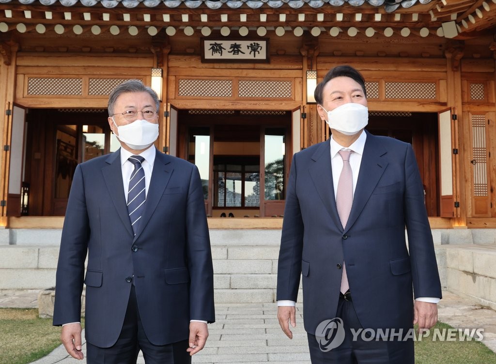President Moon Jae-in (L) and President-elect Yoon Suk-yeol pose for the camera before their dinner meeting at the presidential office Cheong Wa Dae in Seoul on March 28, 2022. (Yonhap)