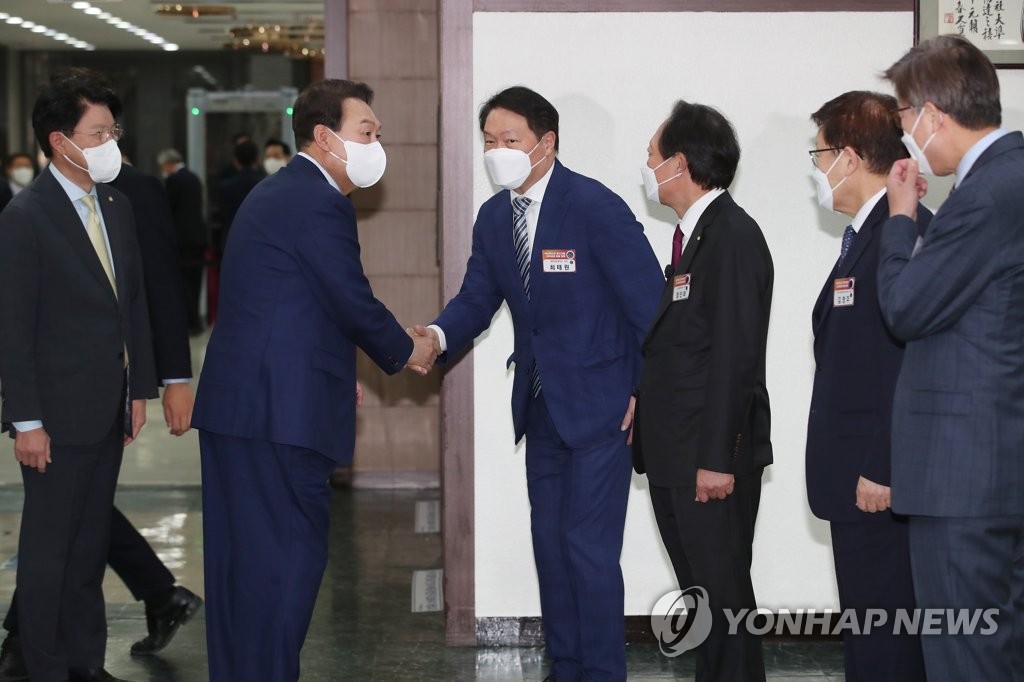 President Yoon Suk-yeol (2nd from L) greets SK Group Chairman Chey Tae-won, currently the head of the Korea Chamber of Commerce and Industry, at an event on April 22, 2022, for the South Korean port city Busan's bid to host the 2030 World Expo. (Pool photo) (Yonhap)