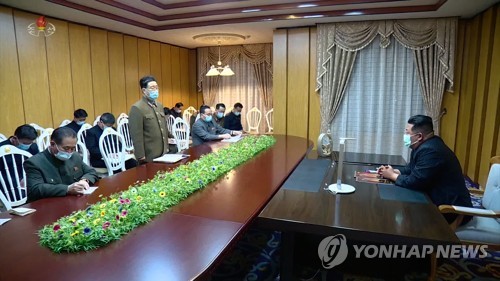 北朝鮮の朝鮮中央テレビが１３日に公開した会議の様子。金正恩氏（右）もマスクを着用している＝（聯合ニュース）≪転載・転用禁止≫