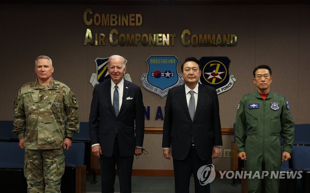 Le président Yoon Suk-yeol (2e depuis la dr.) et le président américain Joe Biden (2e depuis la g.) posent pour une séance photos avec le général Paul LaCamera, commandant des Forces américaines en Corée du Sud (USFK) (à g.), et le général de corps aérien Choi Sung-chun, commandant des opérations aériennes, au Centre coréen des opérations aériennes et spatiales (KAOC), situé sur la base aérienne d'Osan à Pyeongtaek, à 70 kilomètres au sud de la capitale, le dimanche 22 mai 2022.