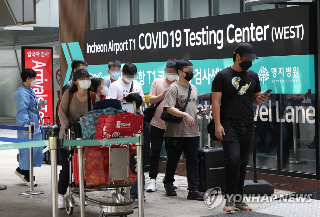 People move to take COVID-19 tests upon arrival at Incheon International Airport, west of Seoul, on May 23, 2022, when South Korea reduced restrictions for entry into the country by allowing rapid antigen tests, in addition to polymerase chain reaction tests. (Yonhap)