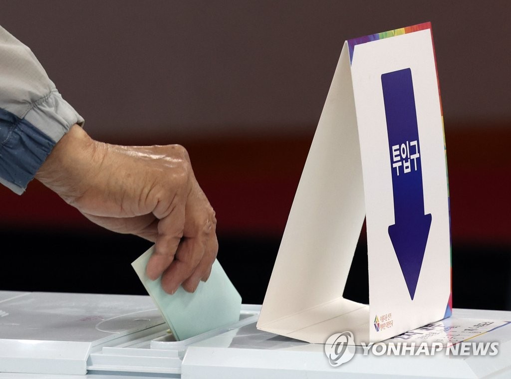 Un électeur dépose son bulletin de vote comptant pour les élections locales dans un bureau de vote à Séoul, le 1er juin 2022. (Yonhap)
